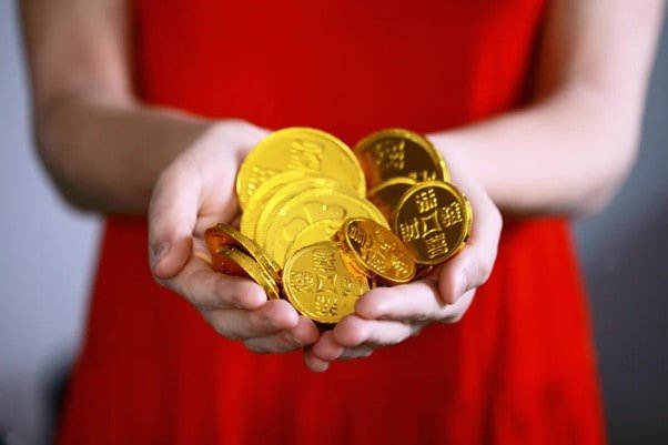woman in red holding a pile of gold coins to prepare for retirement in singapore